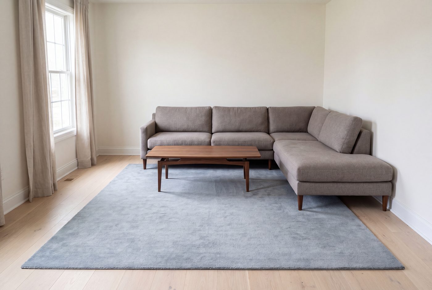 An L-shaped sectional with both arms standing on the front edge of a rug