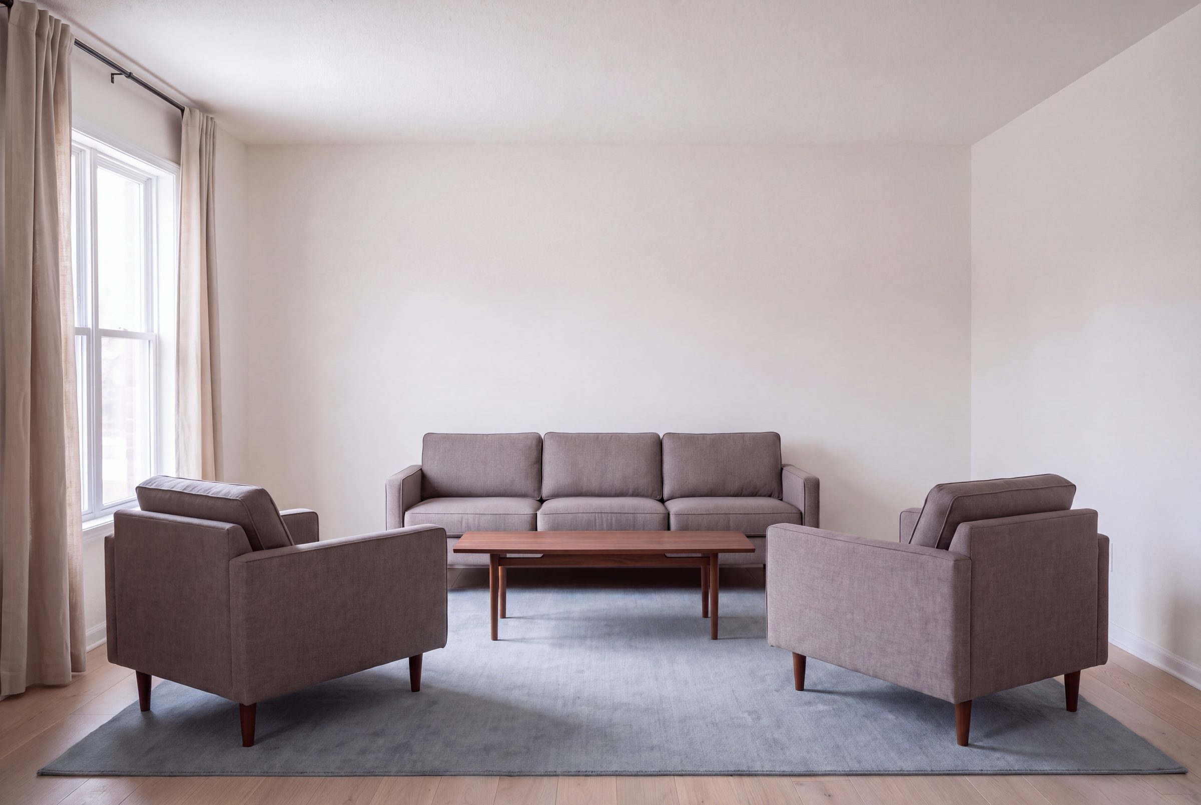 A living room where the front legs of the sofa and both armchairs stand on the rug