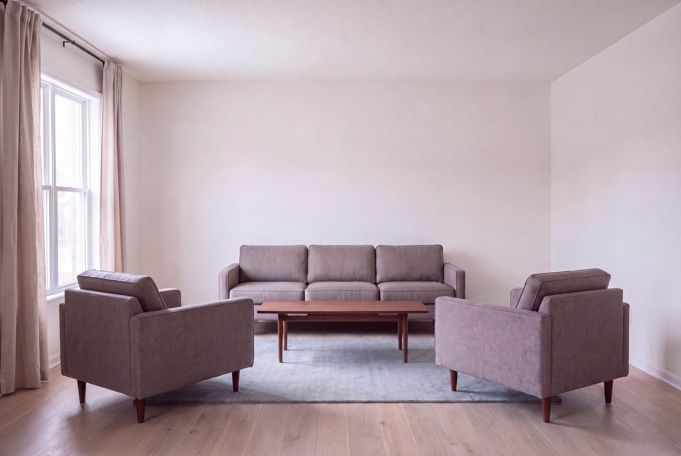 The same room and the same camera, with a 5 by 8 foot rug under the coffee table only and every seat standing on bare floorboards.